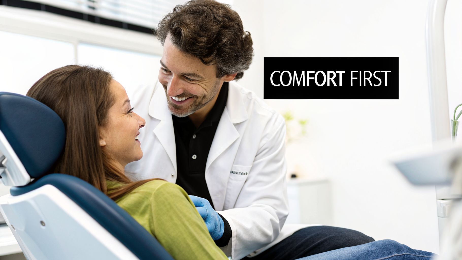 A friendly male dentist smiles at a happy female patient sitting in a modern dental chair, with "COMFORT FIRST" overlaid.